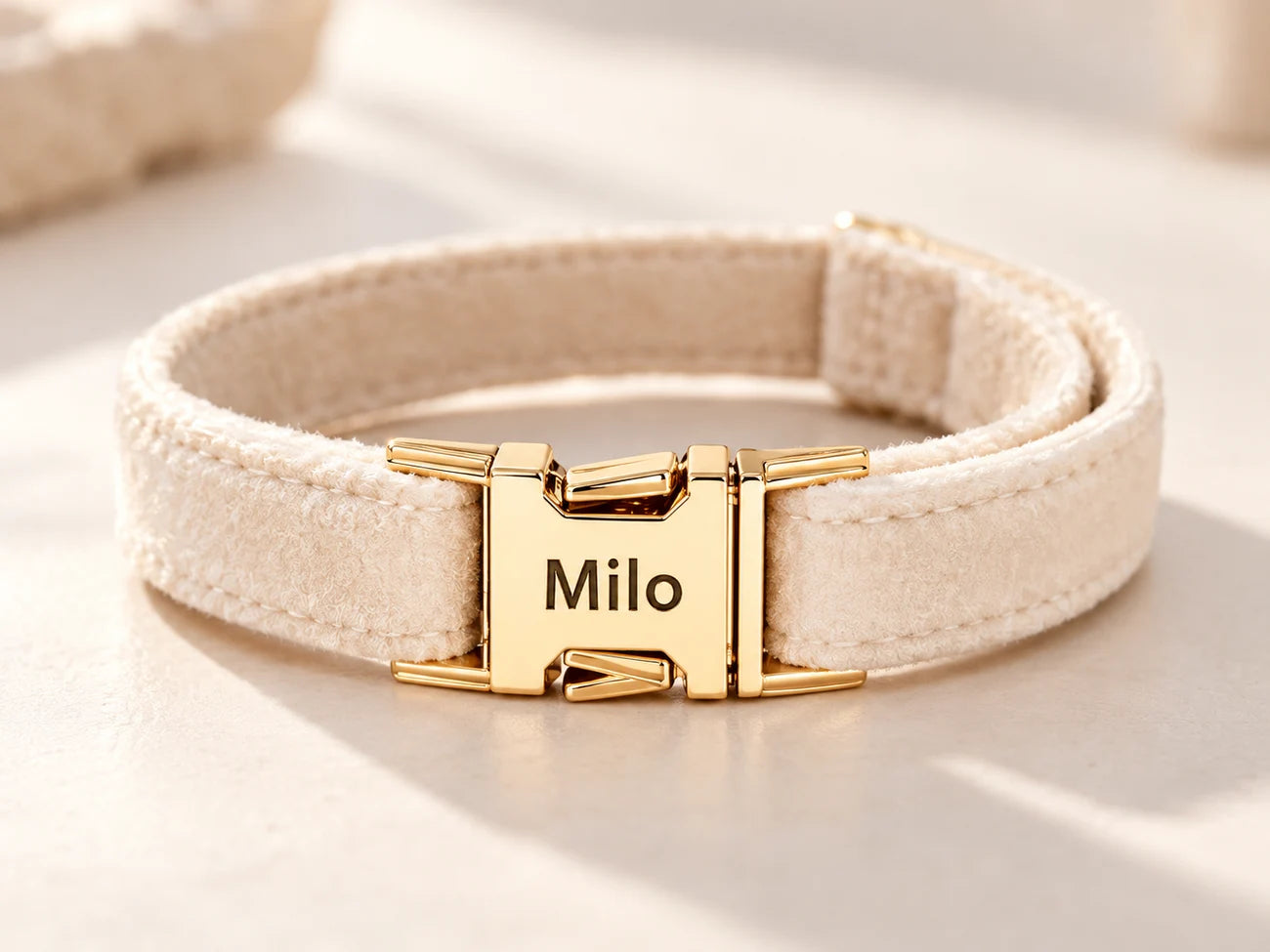Milo engraved on the gold clasp of a cream collar